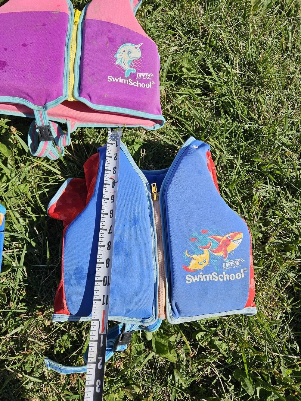 SwimSchool kids life jackets in blue/orange with white chevron pattern and green